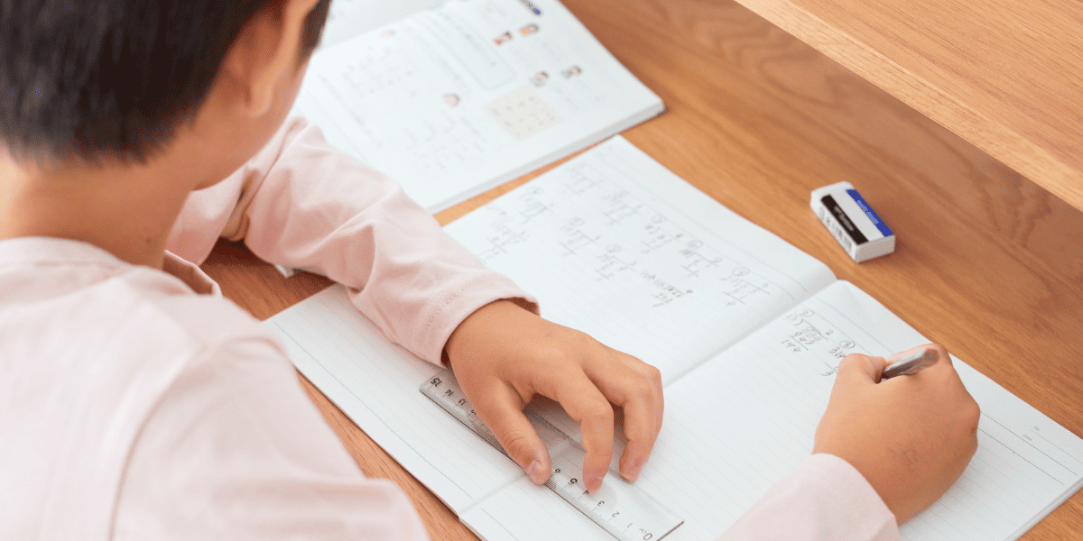 ノートで計算式を解いている少年