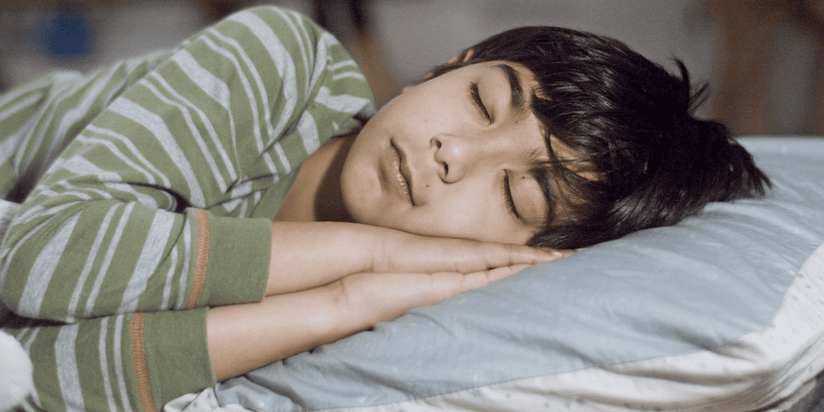 ベッドで寝る少年