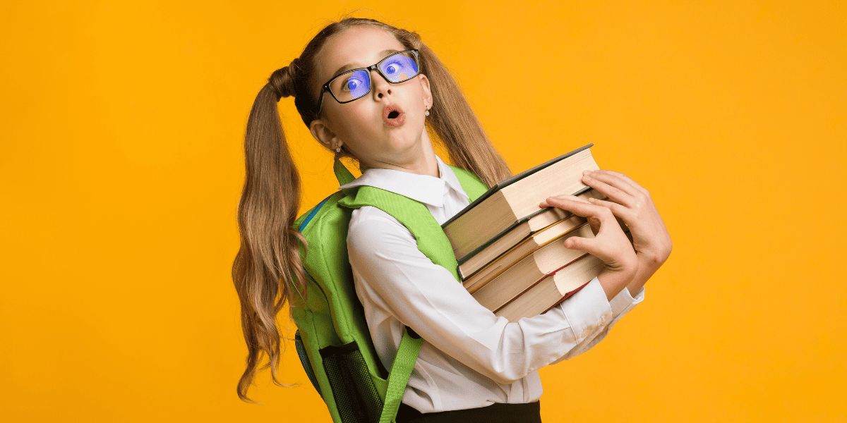 リュックを背負って本を持つ少女