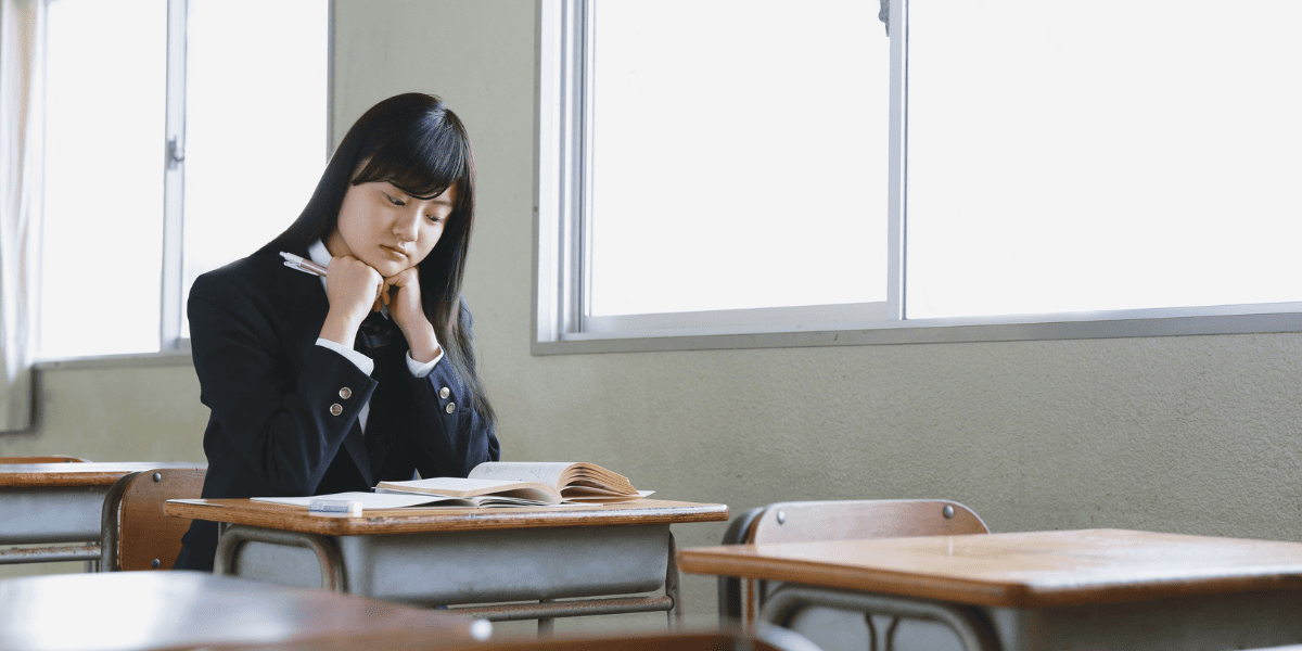 /upload/column/high-school-number-of-absences-3.png 教室でうつむく女子生徒