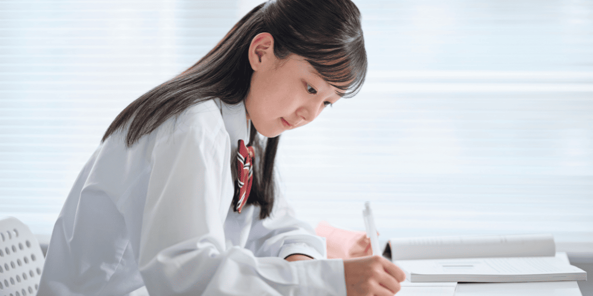 窓際で勉強をしている女子高校生