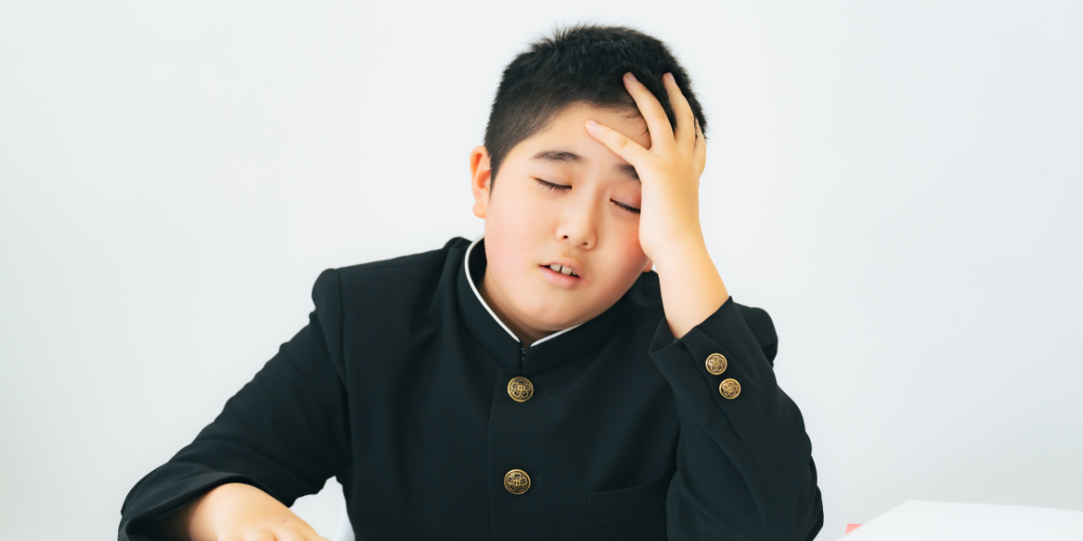 頭を抱えている男子中学生