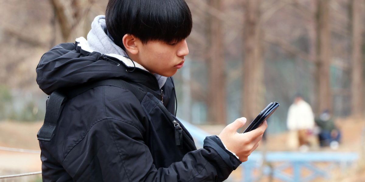 /upload/column/reasons-for-not-attending-school-04.jpg 公園でスマホを見ている男子中学生