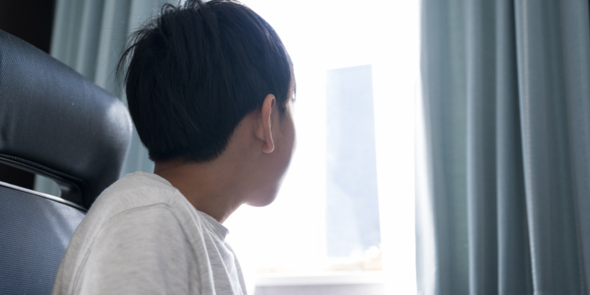 窓の外を眺めている少年