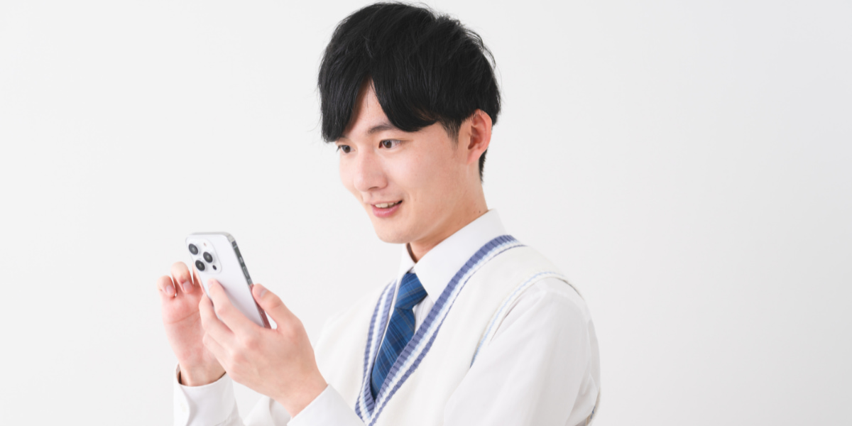 スマホを見ている男子高校生