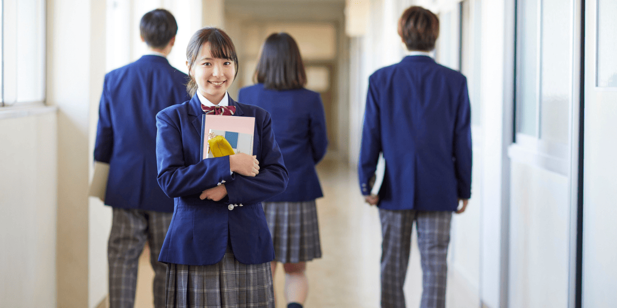 教材を持って廊下に立つ少女