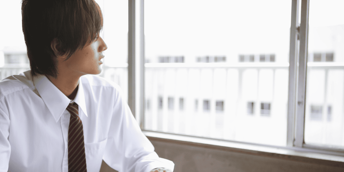 教室から外を見る男子生徒