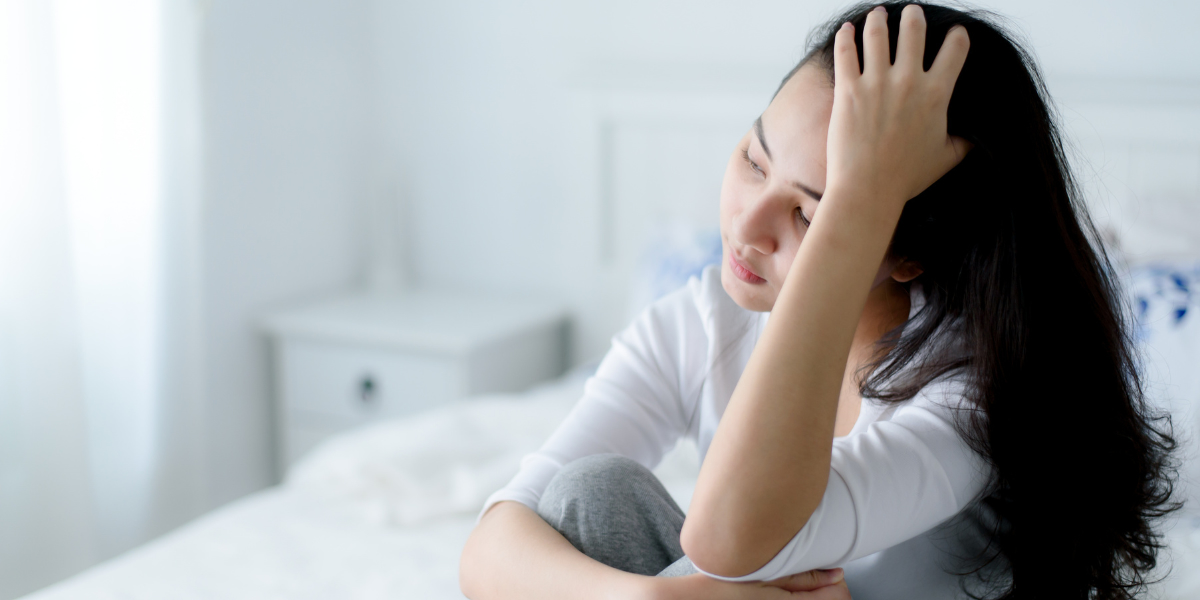 頭を押さえている女性